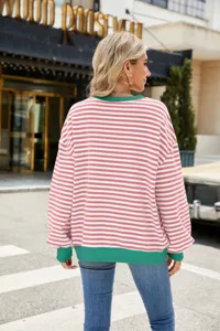 Rosa-weiße gestreifte Oversize-Langarm-Sweatshirt-Detail mit grünen Rippbündchen.