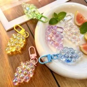 Vista detallada de llaveros coloridos y traslúcidos con forma de uva para bolsos elegantes.