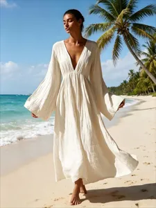 Detailansicht des eleganten V-Ausschnitt Langarm Maxikleids in Weiss am Sandstrand.