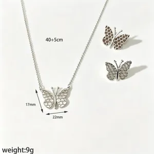 Detailed shot of silver butterfly necklace and matching earrings featuring elegant honeycomb wing design.