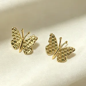 Gold butterfly stud earrings detail close up view showcasing delicate honeycomb textured wings.