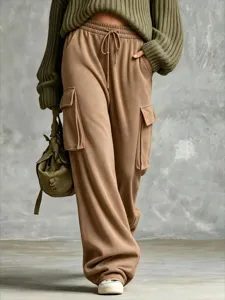 Detail view of casual loose cargo sweatpants in olive green with drawstring and pockets.