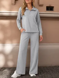 Detail view of the casual grey zip-up top and wide-leg trousers set worn outdoors.