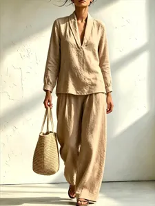 Detailed view of the chic beige long sleeve V-neck shirt and loose wide-leg pants outfit.