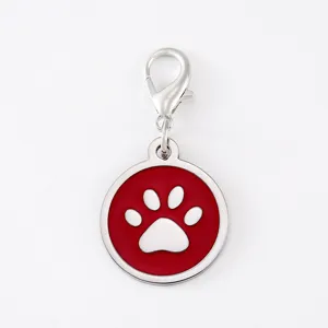 Detailed view of the red enamel pet tag with lobster clasp and cute paw print design.