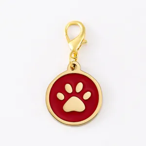 Golden lobster clasp with a red enamel round dog paw print pendant charm detail shot.