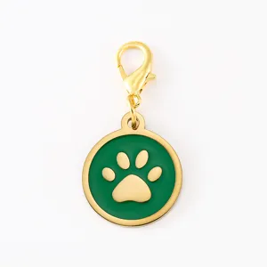 Detailed shot of green enamel dog paw charm with gold lobster clasp, smooth metal finish.
