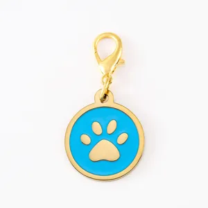 Close-up detail of the gold lobster clasp and blue enamel dog paw print pendant charm.