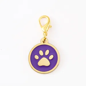 Exquisite gold tone metal dog paw pendant with purple enamel filling and secure lobster clasp.