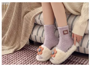 Detail view of women's plush coral fleece sleep socks in cozy purple with soft texture.