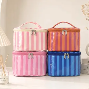 Vista detallada de varios bolsos cosméticos a rayas impermeables en la mesa interior.