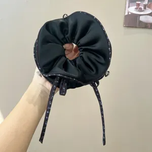 Coletero de satén negro con bonitas cintas florales elegantes para peinados vintage.