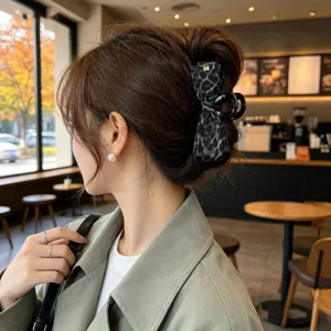 Vue détaillée d'une pince à cheveux élégante avec nœud léopard, accessoire de coiffure chic.