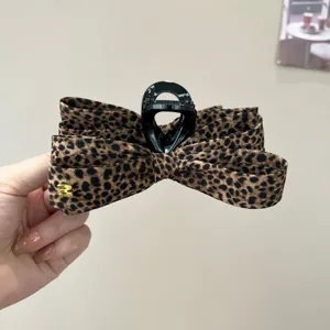 Vue de detail de la pince a cheveux noeud multicouche leopard, accessoire de mode vintage.