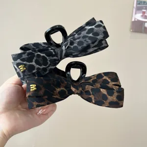 Pince a cheveux noeud motif leopard avec dents noires et accent lettre en metal chic