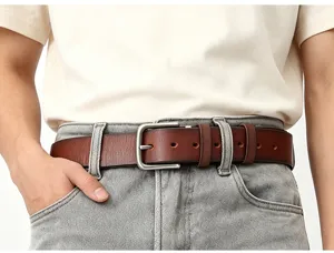 Gedetailleerd close-up van vintage herenriem van echt leer gedragen op casual jeans.