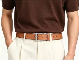Détail de ceinture en cuir marron pour homme avec boucle ardillon argentée élégante.