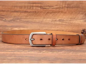 Gros plan détaillé sur la ceinture en cuir de vachette marron avec boucle élégante.