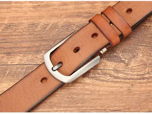 Gros plan sur la texture du cuir véritable et la boucle ardillon classique de cette ceinture.