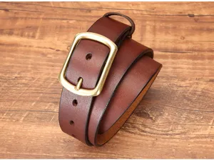 Primo piano dettagliato della elegante cintura in vera pelle marrone con robusta fibbia in metallo.