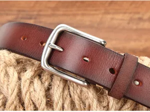 Gedetailleerde close-up van een vintage echt lederen riem met doornsluiting op rustiek touw.