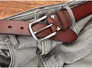 Detailopname van een echte lederen riem met gesp op een achtergrond van grijze jeansstof.