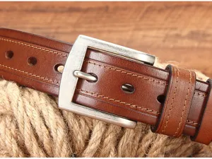 Gros plan détaillé d'une ceinture en cuir véritable marron avec boucle en métal et coutures.