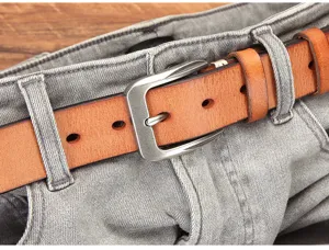 Vue rapprochée détaillée de la ceinture en cuir véritable à boucle ardillon avec jean gris.