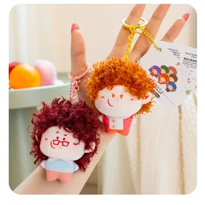 Close-up detail of cute fluffy curly hair doll keychain, soft plush bag pendant accessory.