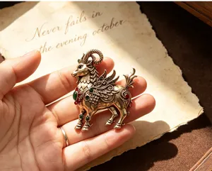 Detailed close-up of vintage winged ram brooch featuring intricate bronze filigree and gems.
