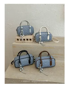 Quilted denim boston handbag with stylish metal charm, versatile casual crossbody pillow bag.