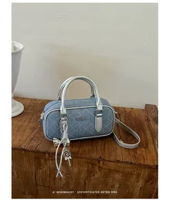 Detailed view of stylish quilted denim pillow handbag with silver metallic handles.
