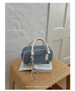Quilted denim pillow bag detail, stylish retro handbag with top handle and chain charms.