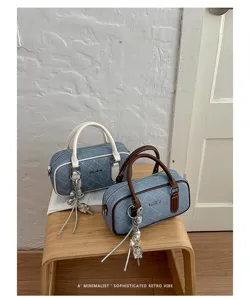 Chic denim quilted pillow bag with stylish handles and charms, perfect for daily commuting.