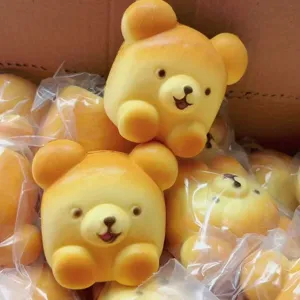Detailed view of cute bear bread squishy toys, slow rebound decompression toy in bulk packing.