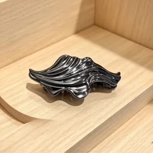 Black glossy irregular wavy hair claw clip, chic metal finish shark clip for elegant updos.