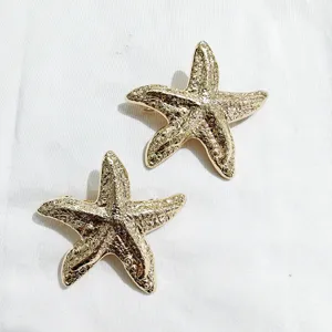 Gold starfish hair clips for women, elegant metal barrettes with textured design for styling.
