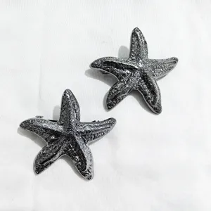 Detailed close-up shot of metallic starfish hair clips with textured design for elegant styling.