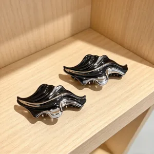 Detailed view of abstract black and silver hair claws, modern minimalist hair accessory.