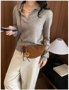 Brown suede half-moon crossbody bag detail showcasing retro design and stylish strap.