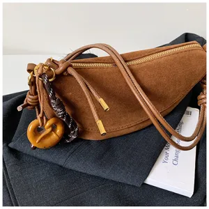 Detailed view of the brown vintage suede crescent shoulder bag with stylish knots and zipper.