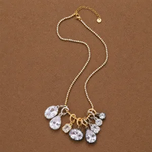 Elegante collar de tenis dorado con colgantes geométricos de cristal y circonitas.