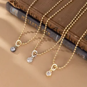 Detalle en primer plano del elegante collar de cadena de cuentas con colgante de circonita y diseño.