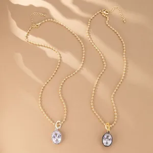 Exquisito juego de collares con colgante de cristal ovalado y finas cadenas doradas.