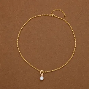 Elegante collar de cadena de cuentas doradas con un colgante de circonita brillante.