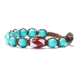 Handmade turquoise red dzi bead braided bracelet detailed view showcasing ethnic cord craftsmanship.