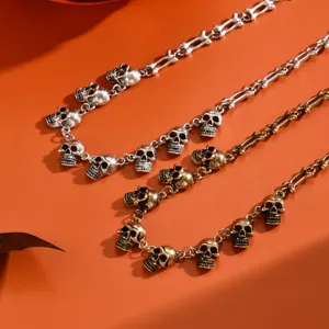 Close-up van gotische punk schedel en bot metalen kettingen in zilver en bronskleur.