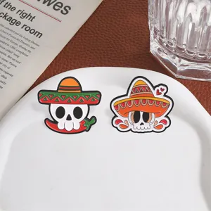 Close-up of Mexican Day of the Dead sugar skull enamel brooch pins set on white tray.