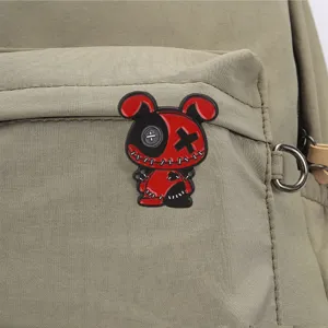 Gros plan d'une broche en métal de lapin vaudou gothique sombre, design cousu rouge et noir vif.