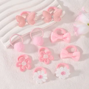 Close-up details of cute pink girls hair tie set featuring bows, flowers and pom-poms.